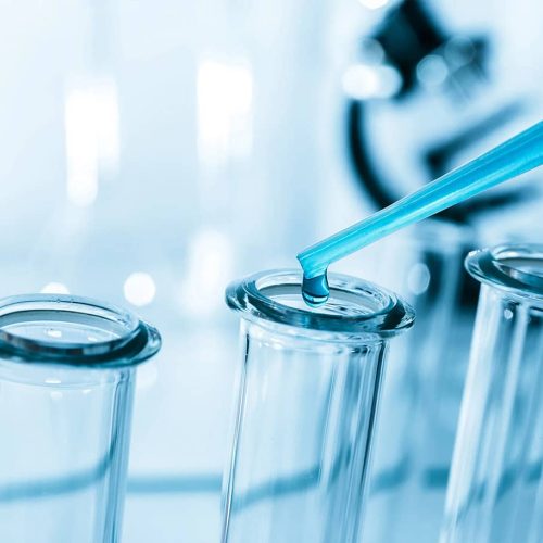 Pipette Adding Fluid To One Of Several Test Tubes .medical Glass